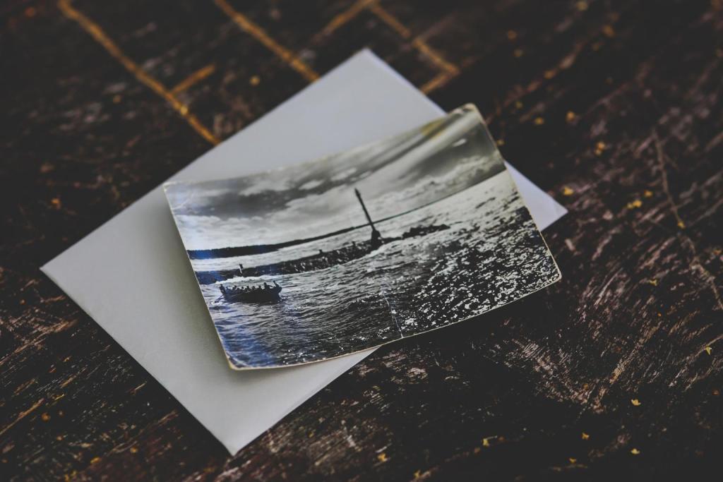 Een vintage zwart-witfoto ligt op een donker houten oppervlak en toont een turbulent zeegezicht met een vuurtoren in de verte en een bootje op het water. Onder de foto is gedeeltelijk een envelop zichtbaar, die doet denken aan ontwikkelingspostkaarten uit vervlogen tijden.
