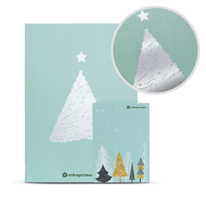 Een mintgroene kerstkaart met een kerstboom van zilverfolie met een ster erop. Erbij hoort een kleinere kaart met verschillende gestileerde bomen in verschillende kleuren. Een close-up toont het reflecterende foliedetail op de boom.